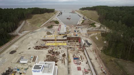 aerial orbit shot of the huge construction site of the vistula spit canal, shipping channel for container ships