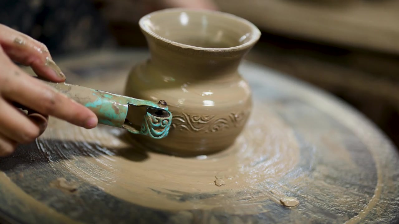 Vasaio che intaglia motivi intricati su un vaso di argilla su un tornio