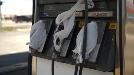 gas pumps at shut down fuel petrol station with plastic bags on all the nozzles due to gas shortage crisis and covid pandemic