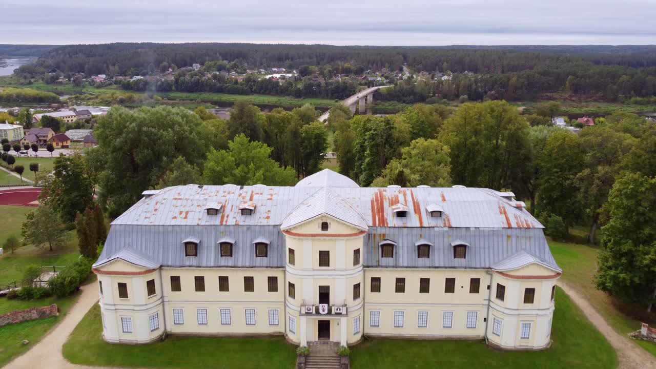 Kraslava manor (castle) with rusty rooftop, aerial fly backward view