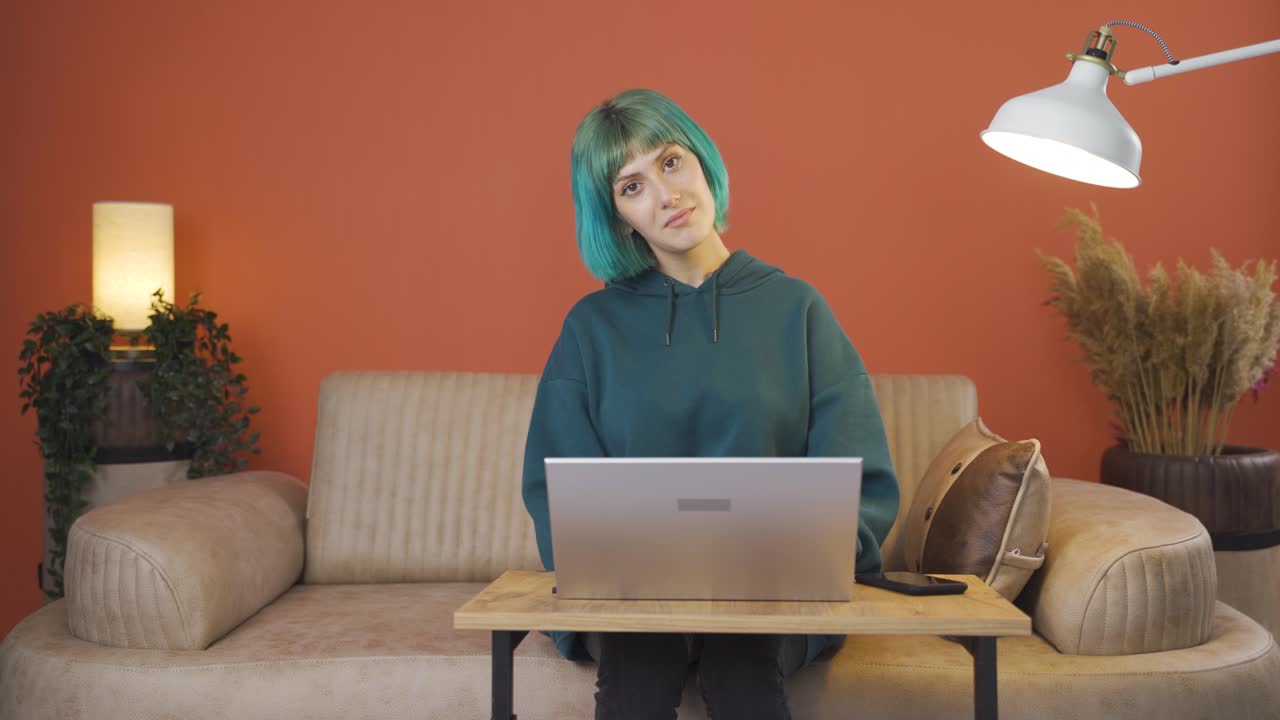 젊은 여성이 카메라에 인사를 하고 박수를 치고 있습니다.