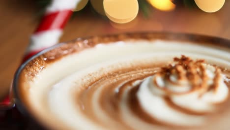 closeup of a hot chocolate with whipped cream and sprinkles for the holidays