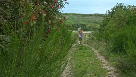 Eine-Frau-In-Ihrem-Kurzen-Kleid-In-Verschiedenen-Farben,-Die-Im-Gartenpark-Durch-Den-Gehweg-Läuft,-Mit-Einem-Ausdruck-Von-Glück-Und-Dankbarkeit