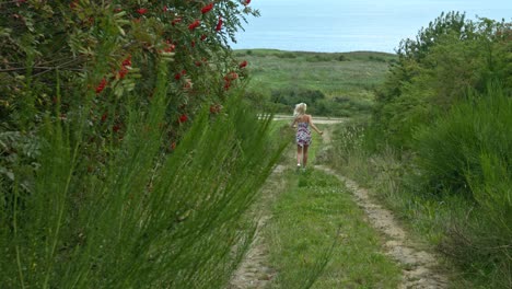 a woman in her short dress of different colour running in the garden park through the walking path with an expression of happiness and gratitude