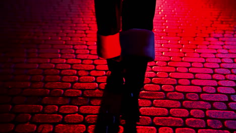 santa claus walk on pavement. legs of father frost at christmas outdoors. boots of santa walking on a pavement at dark. red lighting. back view.