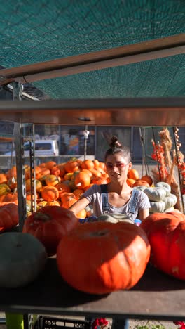 woman selling pumpkins at a market