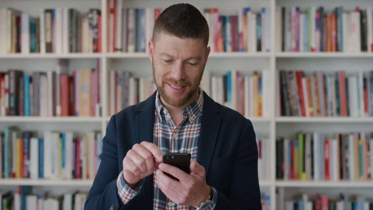 retrato joven hombre de negocios usando un teléfono inteligente trabajando en línea navegando mensajes sonriendo feliz profesional masculino disfrutando de la tecnología de teléfono móvil cámara lenta