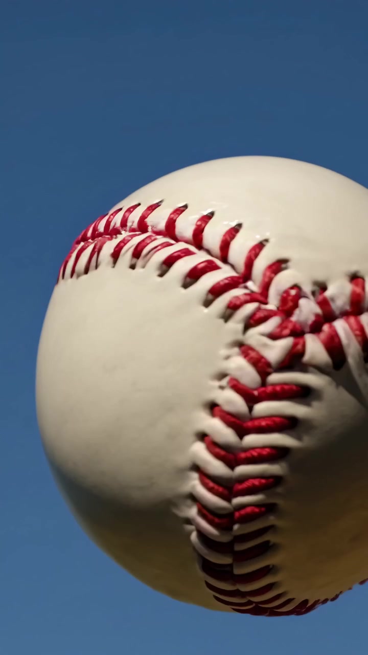 Palla da baseball con cuciture rosse che gira in un cielo blu