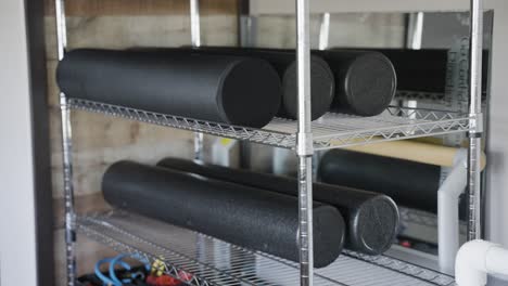 an image showcasing foam rollers neatly arranged on a gym shelf in a close-up view