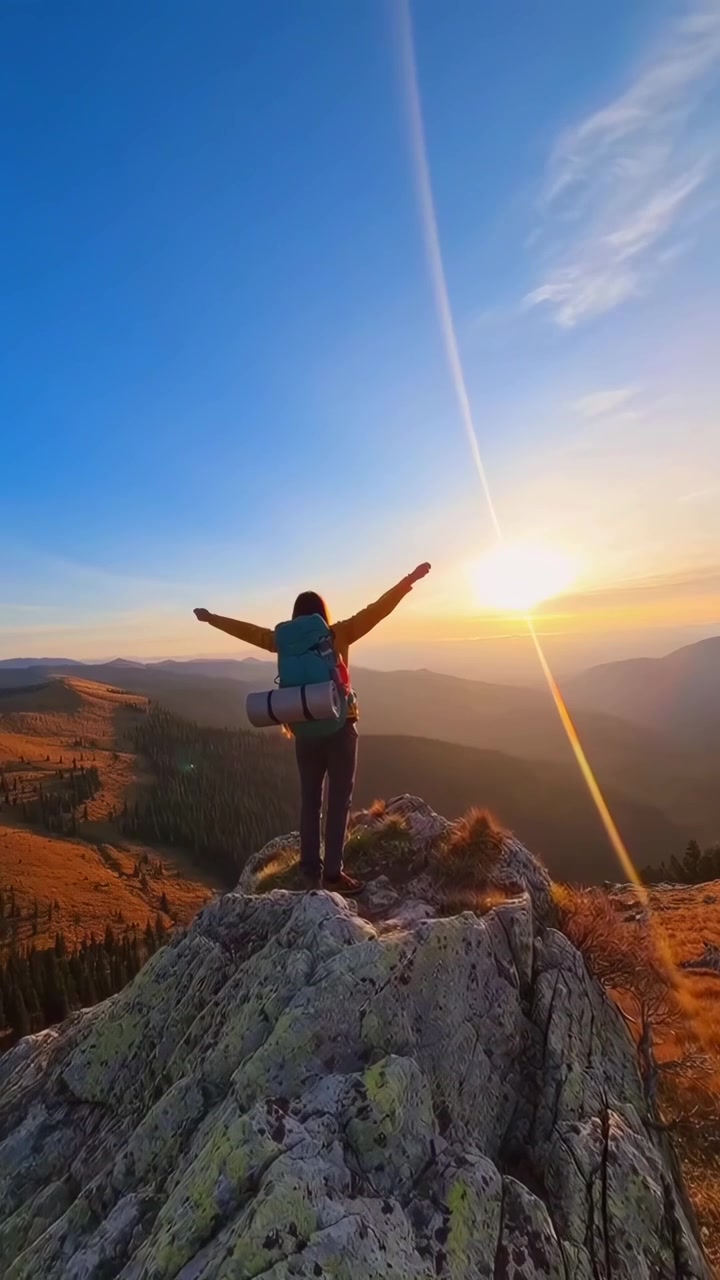 Donna escursionista felice che si scatta un selfie e festeggia sulla cima di una montagna al tramonto