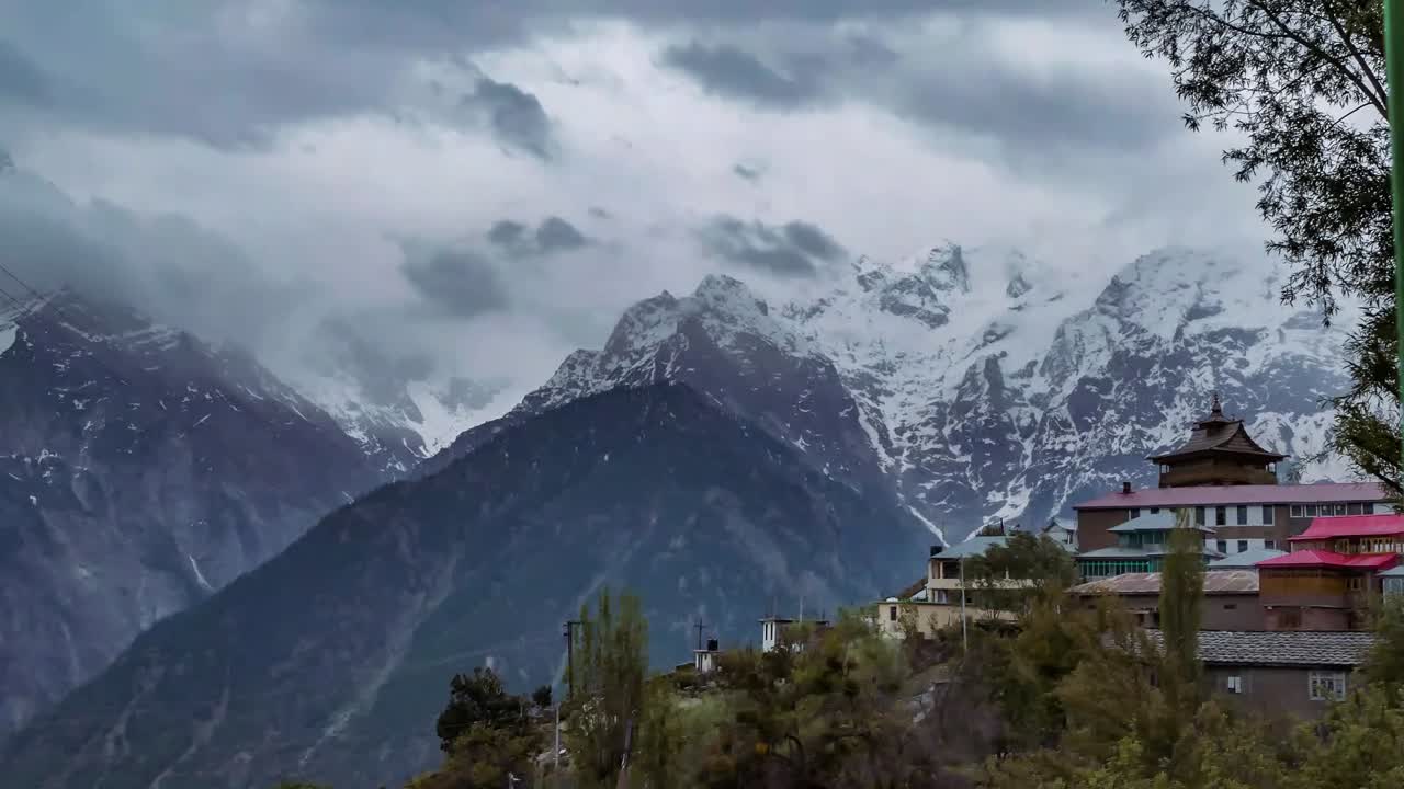 Monastery In Village Of Kalpa, Himachal Pradesh, India With Motion Timelapse Of Dramatic Clouds Above Snowy Mountains In Background - medium shot