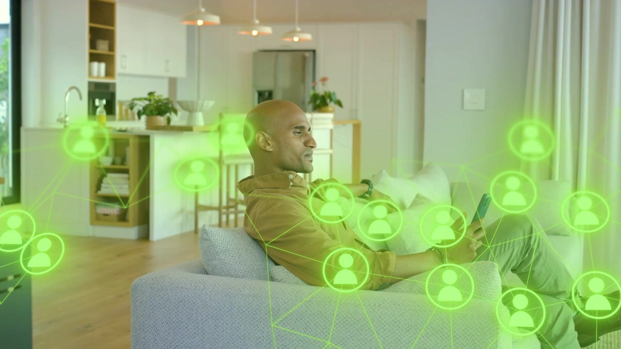 Uomo che si muove sul divano mentre usa un tablet, con una sovrapposizione di rete verde che si intensifica intorno alla tecnologia per il lavoro a distanza