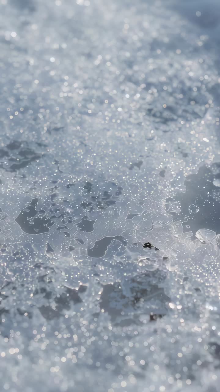 Vertical video: Showing granular ice melting on path as sunlight and camera moving, revealing beads