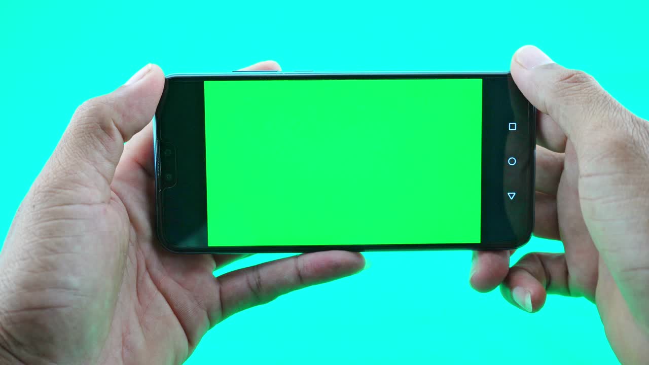 녹색 화면 배경 에 스마트폰 이나 드폰 을 들고 있는 사람 의 손