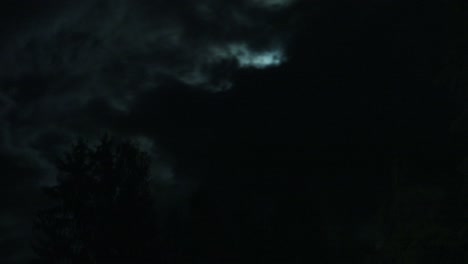 timelapse of the moon hiding behind dark clouds