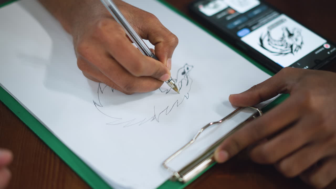 Close view of detailed eagle sketch on white paper with pencil stroke texture captured under soft overhead light revealing intricate wing feather pattern talon curve beak contour and focused draft technique in art session