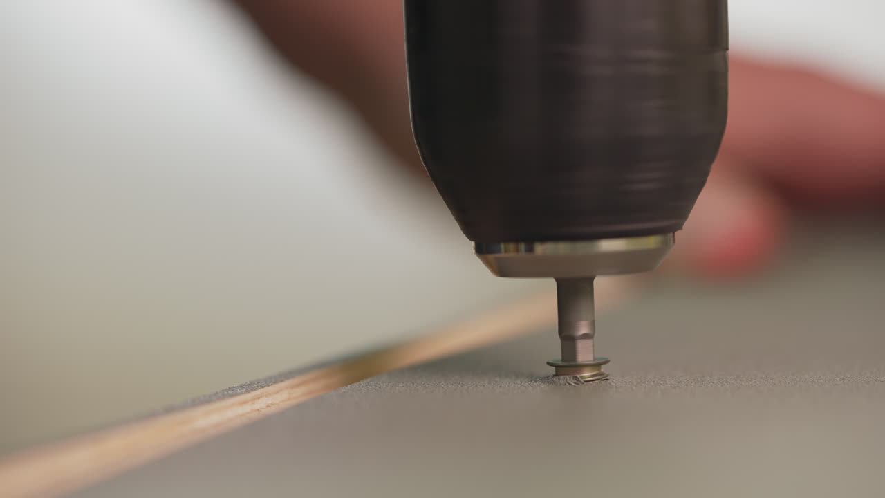 남자 는 집 에 가구 를 조립 하는 데 드릴 을 사용 하여 스크류 를 설치 한다