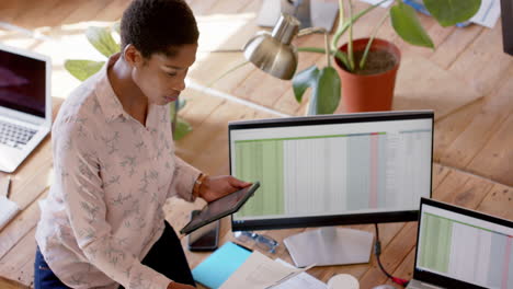 Young-African-American-businesswoman-analyzes-data-at-her-office-desk