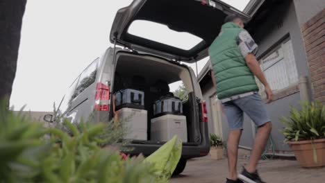 energetic man loading a car for a road trip, camping, and long-distance travel leaving for summer adventure