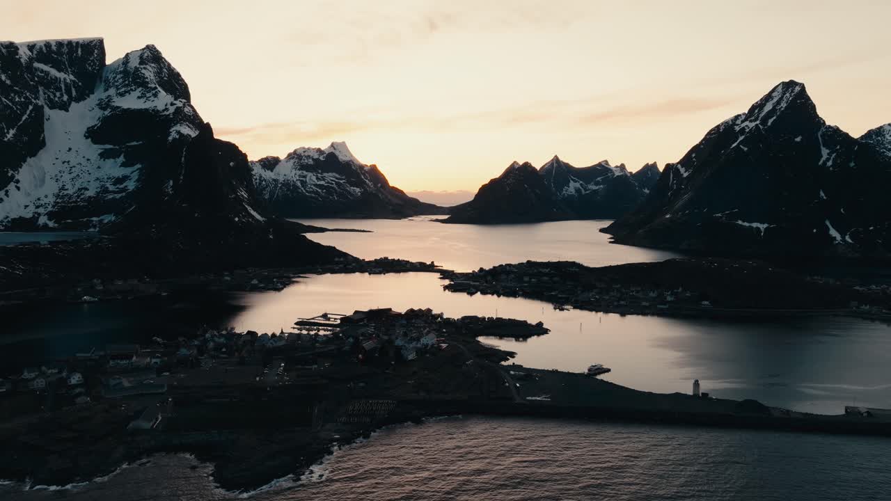 Reine, Lofoten Islands, Nordland, Norway - A Stunning Coastal Village Surrounded by Towering Peaks and Tranquil Waters at Sunset - Aerial Drone Shot