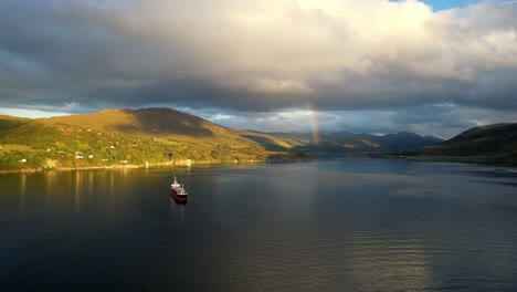 Una-Toma-Cinematográfica-Súper-Genial-De-La-Hermosa-Loch-Broom-Ullapool-Mientras-El-Sol-Se-Pone-Sobre-Las-Islas-De-Verano-En-Las-Tierras-Altas-De-La-Costa-Noroeste-De-Escocia-Con-Un-Bote-En-La-Isla-Agradable