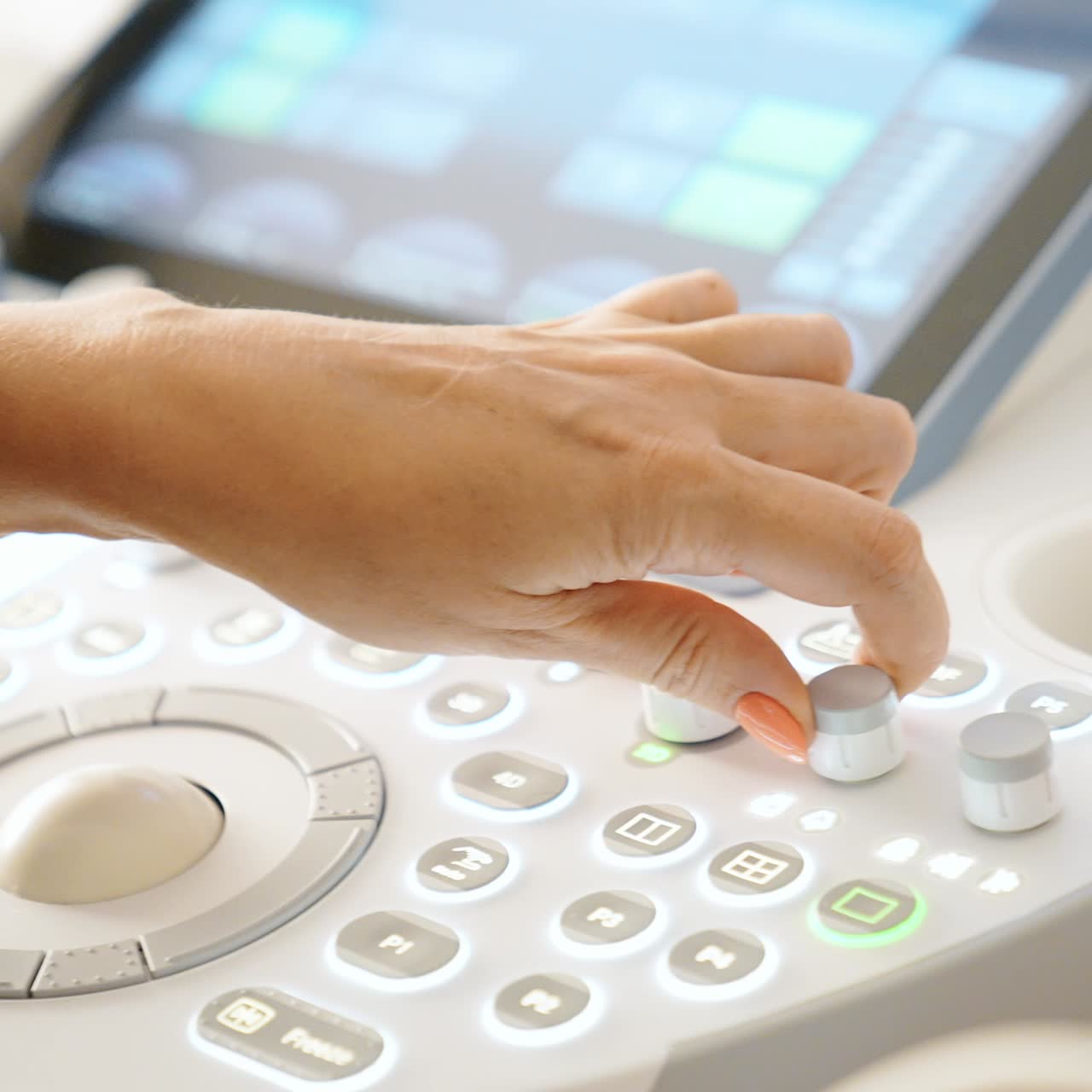 Hand of female doctor work at ultrasound machine. Medic performs sonography examination of a patient. Close up