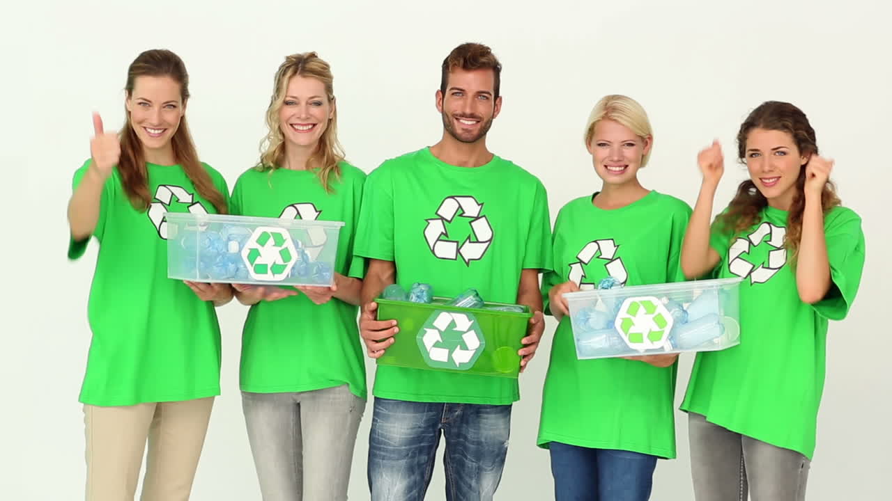 Team of environmental activists smiling at camera holding boxes