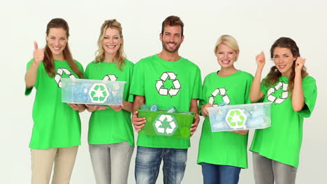 team of environmental activists smiling at camera holding boxes