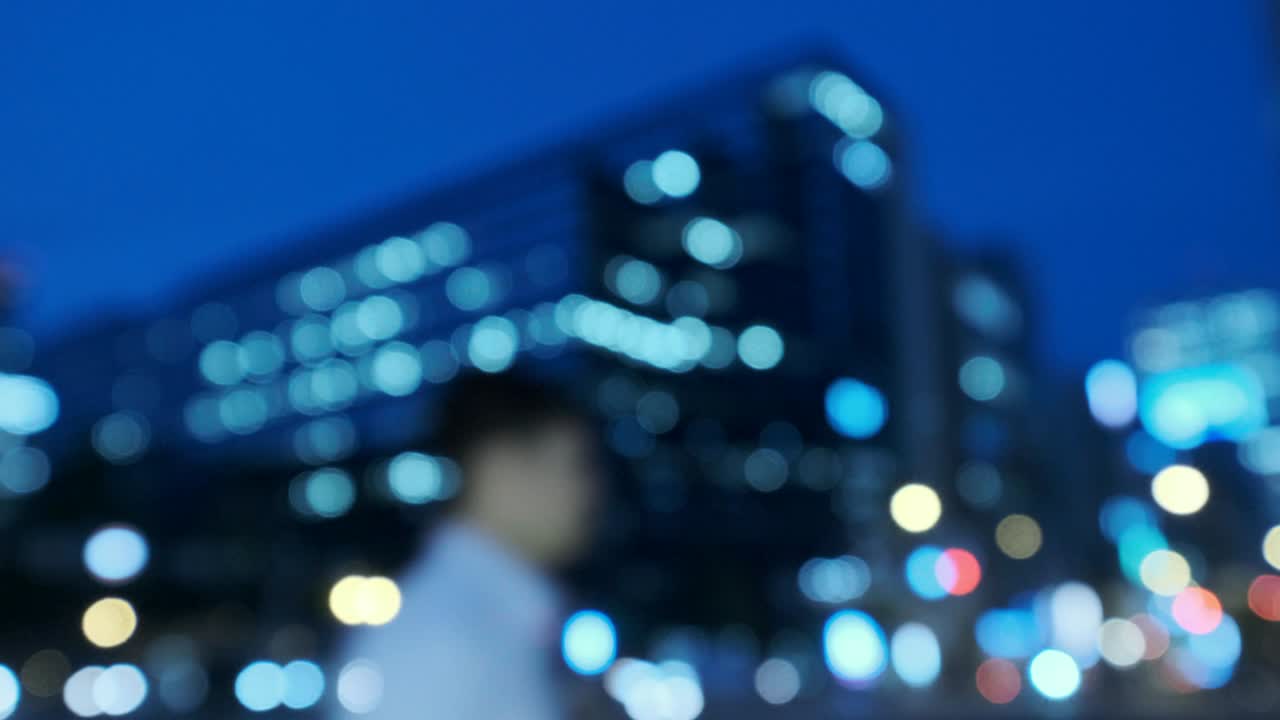 4k tono fresco vídeo desenfocado de vista nocturna urbana con transporte y transeúntes