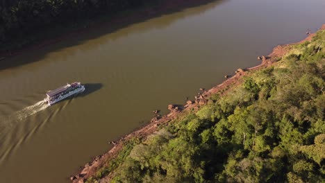 Vista-Aérea-De-Un-Barco-Turístico-Navegando-Al-Atardecer-En-El-Río-Iguazú-En-La-Frontera-Entre-Argentina-Y-Brasil-En-América-Del-Sur