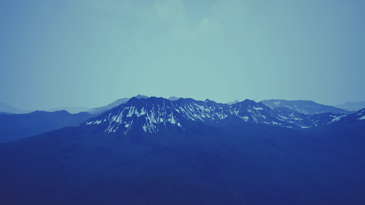 Snowy mountain landscape at dusk with a blue sky above