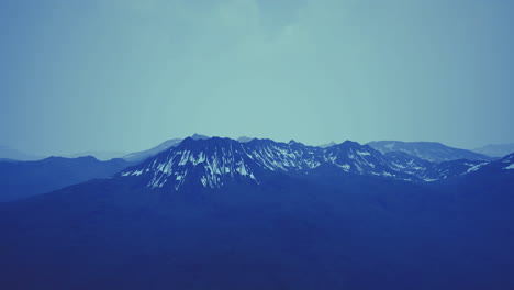 snowy mountain landscape at dusk with a blue sky above