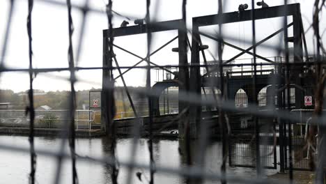 rainy anderton canal industrial boat lift waterway through fenced security gates dolly left