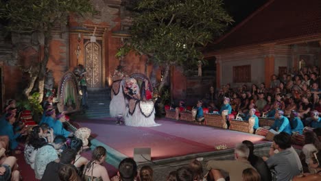 people watching traditional barong dance performance at ubud palace bali, indonesia - wide angle, slow motion