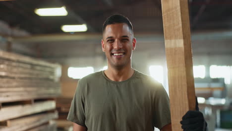 man holding lumber in workshop