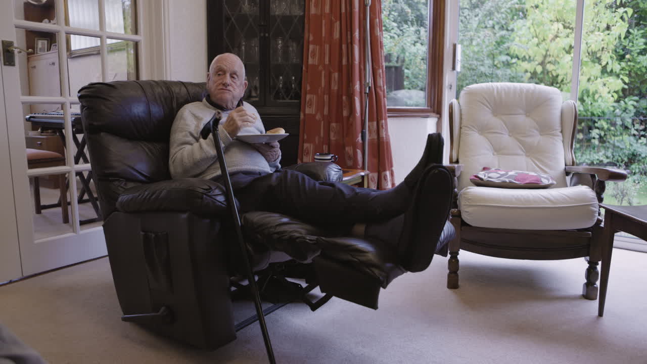 Senior Man Relaxing in Recliner Eating