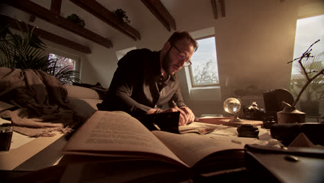 man reading and writing in a home office