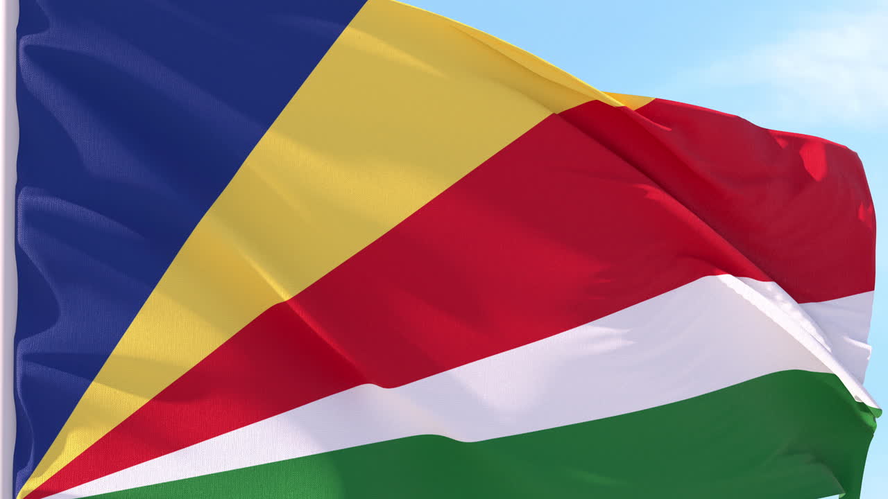 Bandiera delle Seychelles che sventola al vento contro il cielo blu
