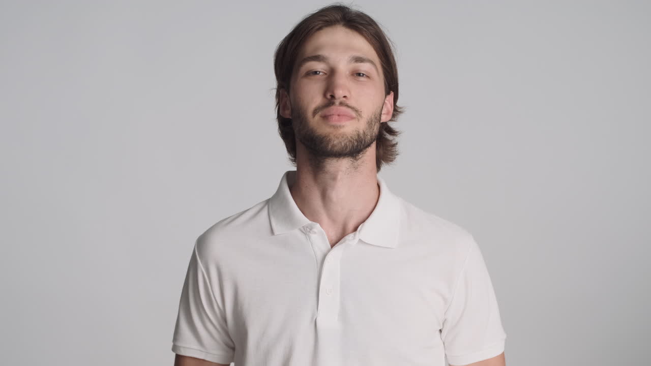 hombre caucásico frente a la cámara sobre un fondo gris.