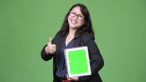 una hermosa mujer de negocios asiática madura mostrando una tableta digital