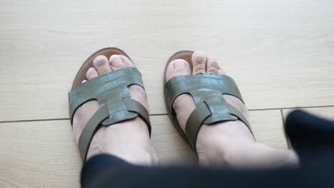 person wearing olive green leather sandals