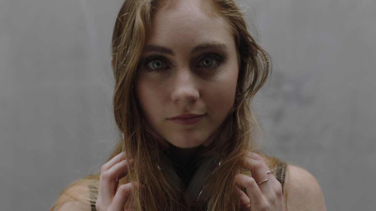 hermosa mujer caucásica que disfruta escuchando música se quita los auriculares mirando a la cámara