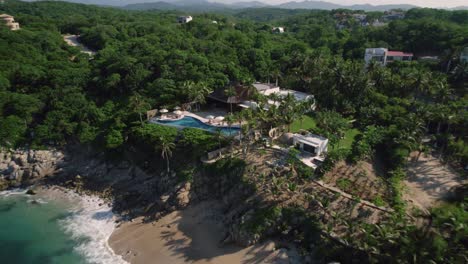 huatulco hotel destination surrounded by a sandy beach with sea and palm jungle