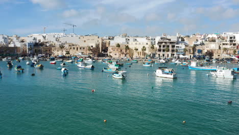 fishing boats in marsaxlokk village in malta - drone shot