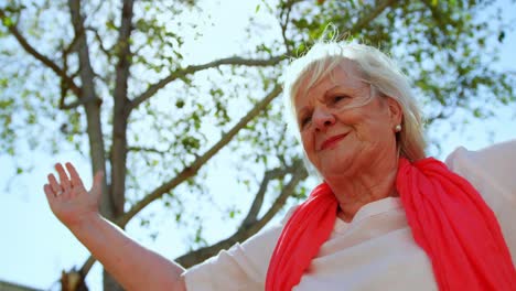 vista de bajo ángulo de una mujer mayor caucásica activa realizando yoga en el jardín de un asilo de ancianos 4k