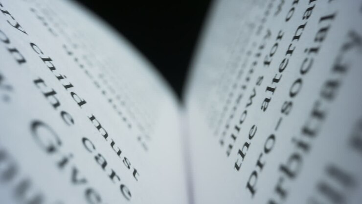 Libro aperto con pagine bianche su sfondo nero. Primo piano di un libro chiuso.