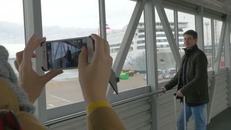 Woman-with-cell-taking-picture-of-a-man-in-dockyard