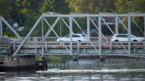 Toma-De-Seguimiento-Izquierda-De-Un-Automóvil-Cruzando-Un-Puente,-Tráfico-Ligero