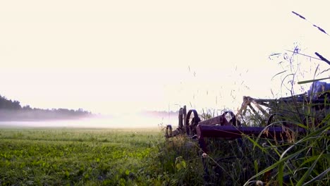 timelapse of old old rusty harrow - farm equipment with moving fog in the background