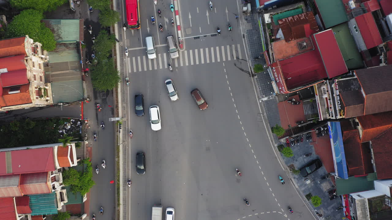 Vertical drone shot over Âu Cơ in Hanoi, showing dense traffic, red buses, buildings, cars, trucks and motorbikes